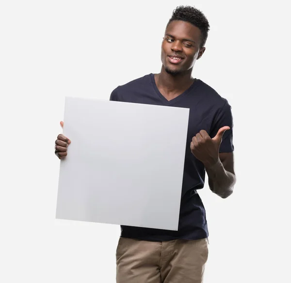 Young African American Man Holding Banner Pointing Hand Finger Happy — Stock Photo, Image