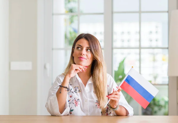 Jeune Femme Maison Tenant Drapeau Russie Visage Sérieux Penser Question — Photo