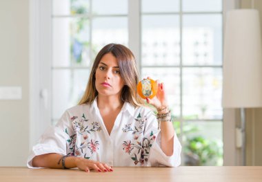 Genç kadın evde acımak yüz ciddi düşünüyorum üstünde kendine güvenen bir ifade ile çürük turuncu holding