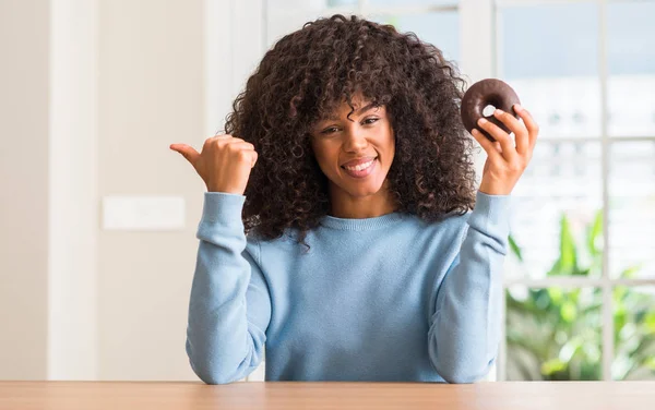 Unga Afroamerikanska Kvinna Som Håller Chocolate Donut Hemma Pekar Med — Stockfoto