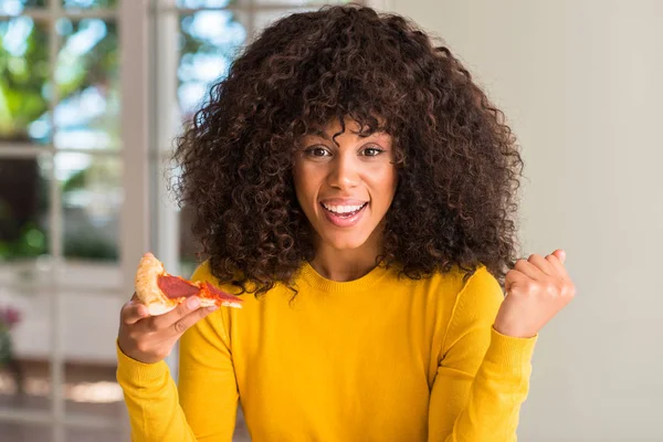 Afrikalı-Amerikalı kadın gurur çığlık ve zafer ve başarı çok heyecanlı, kutluyor pepperoni pizza dilimi yemeye hazır duygu tezahürat