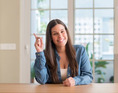 Bir fikir ya da soru işaret parmağı ile mutlu yüz genç güzel kadın evde şaşırttı, number one