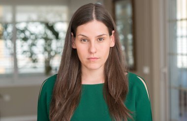 Genç güzel kadın evde akıllı yüzünde ciddi düşünme emin bir ifade ile