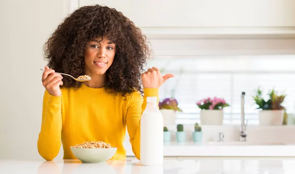 Afro Americana Comendo Cereais Leite Casa Apontando Com Mão Dedo — Fotografia de Stock