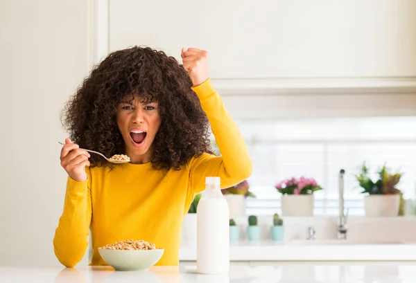 非洲裔美国妇女吃谷类和牛奶在家中懊恼和沮丧的呼喊与愤怒 疯狂和叫喊与举手 愤怒的概念 — 图库照片