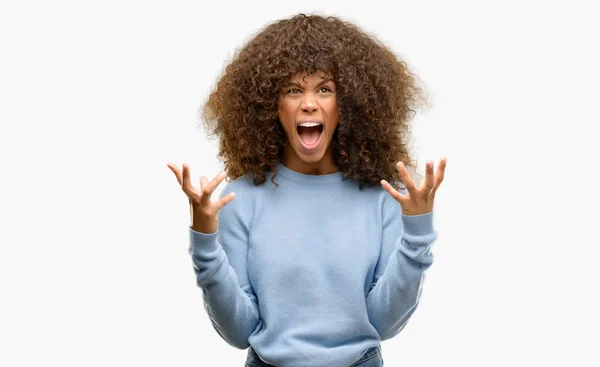 非洲裔美国妇女穿着一件毛衣疯狂和疯狂的呼喊和咆哮与积极的表达和手臂提出 挫折概念 — 图库照片