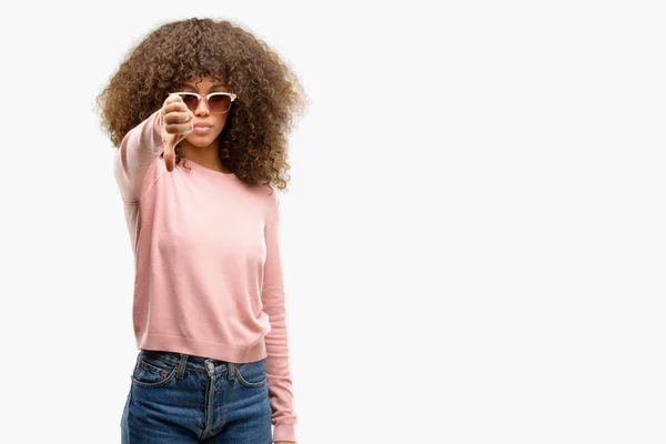 アフリカ系アメリカ人女性は不幸と怒りの拒否反応を示さずとジェスチャーを親指で負を探してピンクのサングラスをかけています 不適切な表現 — ストック写真