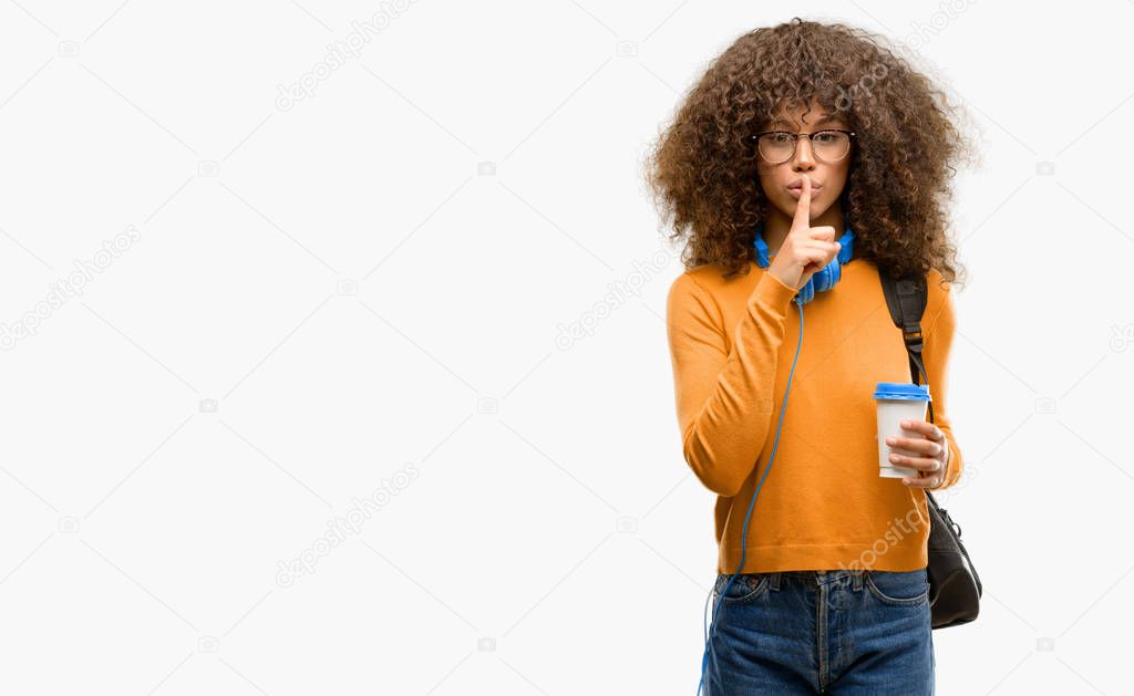 African american student woman with index finger on lips, ask to be quiet. Silence and secret concept