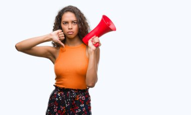 Kızgın yüz, eksi işareti aşağı antipati başparmak ile gösterilen, ret kavramı ile megafon tutan genç İspanyol kadın