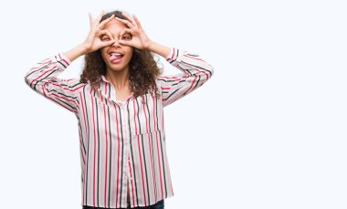 Güzel genç İspanyol kadın dilini, parmaklarının arasından baktığını yapışmasını dürbün gibi ok jest yapıyor. Deli ifade.