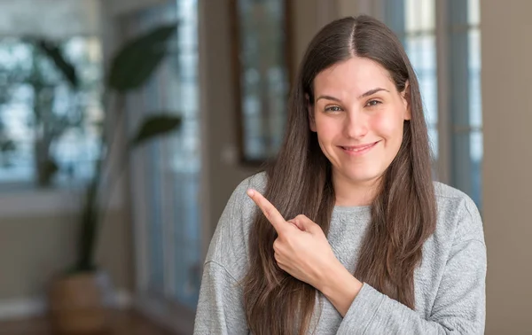 Young Beautiful Woman Home Cheerful Smile Face Pointing Hand Finger — Stock Photo, Image