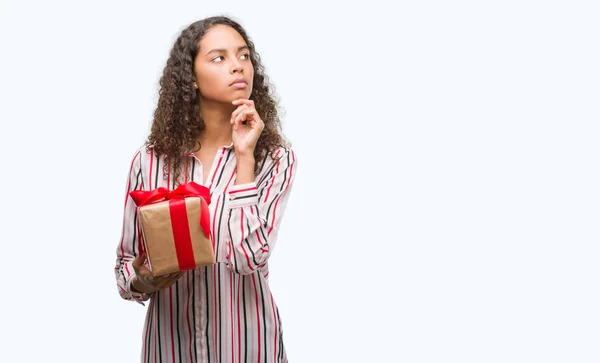 Joven Mujer Hispana Enamorada Sosteniendo Presente Cara Seria Pensando Pregunta — Foto de Stock