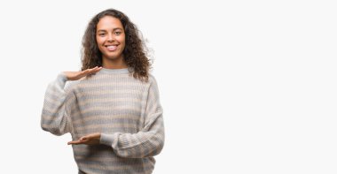 Çizgili kazağı ile büyük ve büyük boy işaret, ölçü birimi sembol gösteren el el hareketi giyen güzel genç İspanyol kadın. Kameraya bakarak gülümsüyordu. Ölçüm kavramı.