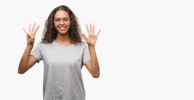 Gösterilen ve parmakları ile işaret güzel genç İspanyol kadın gözlük kendinden emin ve mutlu gülümseyerek ise dokuz numara.