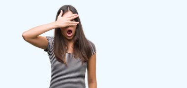 Mahcup ifadeyle parmaklarımın arasından yüz ve gözler el ile kapsayan şok bakmak genç güzel İspanyol kadın arıyor.