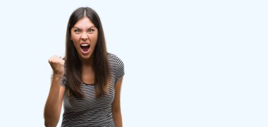 Genç güzel İspanyol kadın öfkeli ve sinirli sinirli ve öfke ile bağırarak süre öfkeli yumruk yükselterek. Öfke ve agresif kavramı.