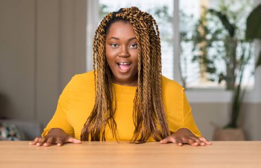 Afrikalı-Amerikalı kadın evde korkuyor şok sürpriz yüz, korkuyor ve heyecanlı korku ifadesi ile