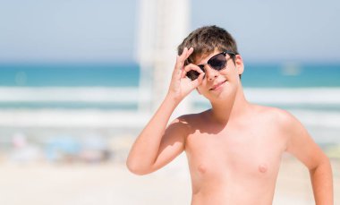 Mutlu yüz el parmaklarının arasından seyir göz üzerinde ok işaretiyle yapıyor gülümseyen ile sahilde tatil günlerinde genç çocuk