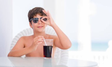 Mutlu yüz el parmaklarının arasından seyir göz üzerinde ok işaretiyle yapıyor gülümseyen ile soda içme tatil günlerinde genç çocuk
