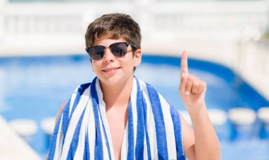 Genç çocuk yüzme, tatillerde bir fikirle sürpriz sahilde havuz veya gülen yüz, bir numara ile işaret parmağı soru