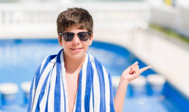 El ve parmak ile tarafına işaret çok mutlu plajda yüzme havuzunda tatil günlerinde genç çocuk