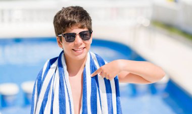 Tatil günlerinde genç çocuk kendisi için sürpriz yüz işaret parmağı plajda yüzme havuzunda