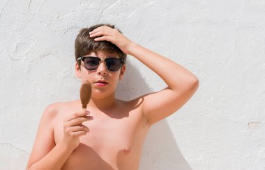 Baş, el ile vurguladı dondurma yemek tatil günlerinde genç çocuk şok utanç ve sürpriz suratla, öfkeli ve sinirli. Korku ve hata için üzgün.