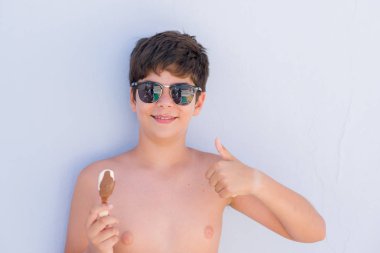 Ok işareti, başparmak ile parmak, mükemmel işareti yapıyor kocaman bir gülümseme ile mutlu dondurma yeme tatil günlerinde genç çocuk