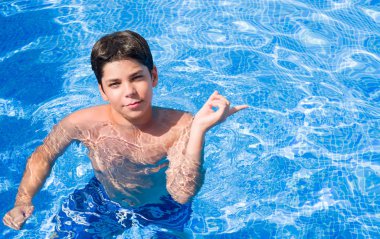 El ve parmak ile tarafına işaret çok mutlu plajda yüzme havuzunda tatil günlerinde genç çocuk