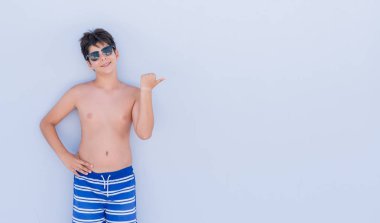 İşaret ve başparmak kadar mutlu yüz gülümseyen tarafı ile gösterilen duvarın üzerinden ayakta tatil günlerinde genç çocuk