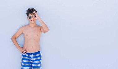 Mutlu yüz el parmaklarının arasından seyir göz üzerinde ok işaretiyle yapıyor gülümseyen duvardan ayakta tatil günlerinde genç çocuk