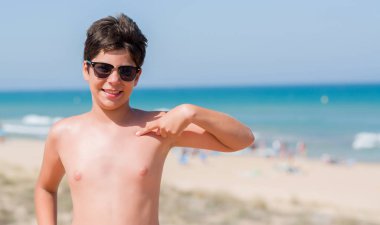 Kendisi için sürpriz yüz işaret parmağı sahilde tatil günlerinde genç çocuk