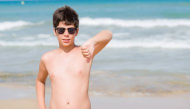 Kızgın yüz, eksi işareti aşağı antipati başparmak ile gösterilen, ret kavramı ile sahilde tatil günlerinde genç çocuk