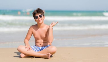 Sahilde el ve parmak ile tarafına işaret çok mutlu tatil günlerinde genç çocuk