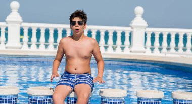 Genç çocuk tatilde plajda bir sürpriz yüz, korkuyor ve heyecanlı korku ifadesi ile şok korkmuş yüzme havuzunda