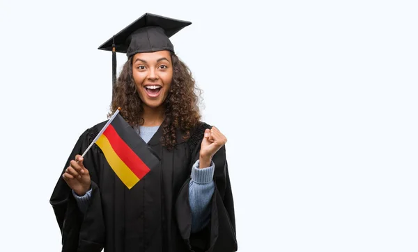 Mujer Hispana Joven Vistiendo Uniforme Graduación Sosteniendo Bandera Alemania Gritando —  Fotos de Stock
