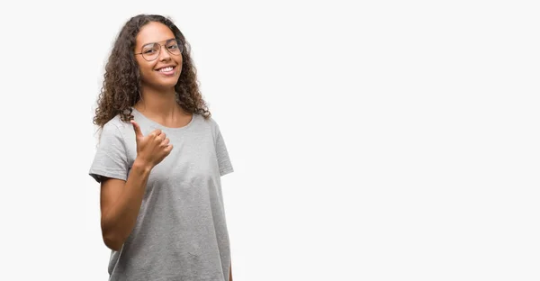 美丽的年轻西班牙裔妇女戴着眼镜做高兴的拇指手势与手 批准表达式看相机与显示成功 — 图库照片