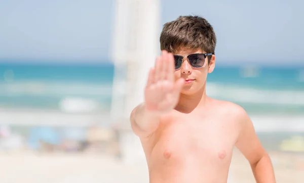 休日にビーチのそばで若い子が防衛ジェスチャー 深刻な自信を持って式に一時停止の標識をやって手を開いてください — ストック写真