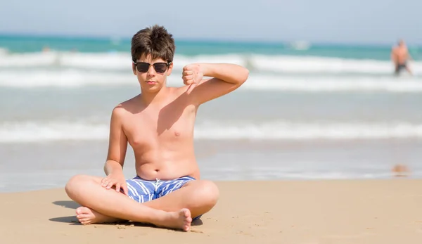 怒った顔 ダウン親指で嫌悪感を示すマイナス記号 拒絶反応の概念とビーチで休日に若い子 — ストック写真
