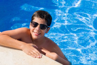 Kendisi için sürpriz yüz işaret parmağı plajda yüzme havuzunda genç çocuk tatilde