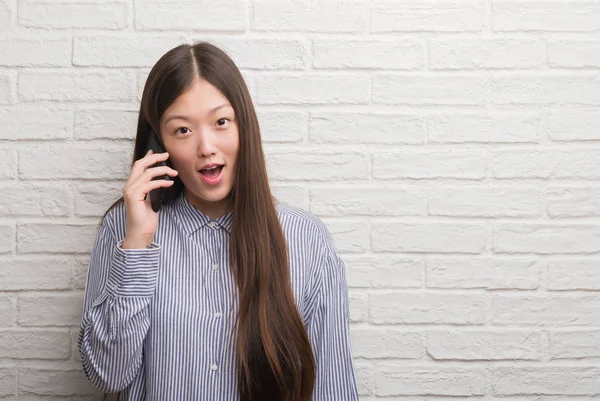 Junge Chinesin Über Ziegelmauer Telefoniert Erschrocken Mit Einem Überraschungsgesicht Ängstlich — Stockfoto