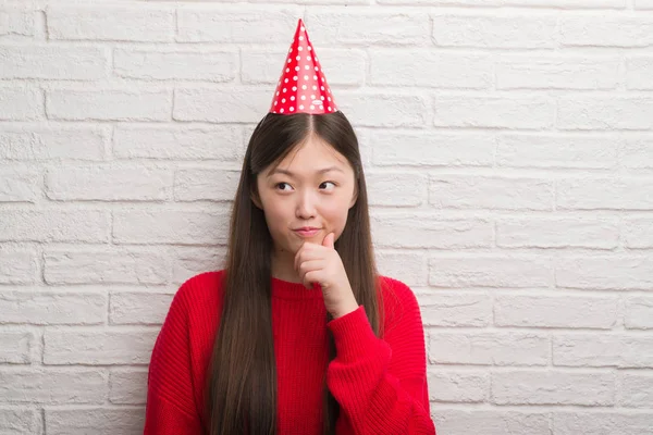 Junge Chinesin Über Ziegelmauer Trägt Geburtstagshut Ernstes Gesicht Über Frage — Stockfoto