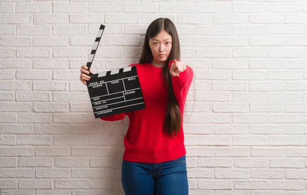 Giovane Donna Cinese Sopra Muro Mattoni Bianchi Tenendo Clapboard Puntando — Foto Stock