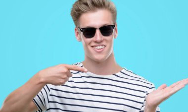 Sunglasess el ve parmak ile işaret çok mutlu giyen genç yakışıklı sarışın adam