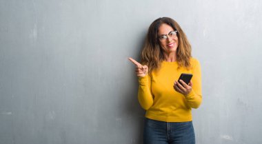 El ve parmak ile tarafına işaret çok mutlu Smartphone kullanan orta yaş İspanyol kadın