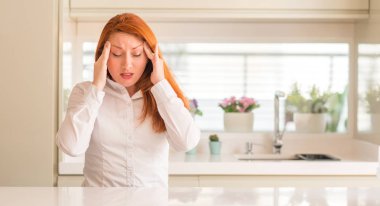 Kızıl saçlı kadına baş baş ağrısı için el ile mutfak çünkü stres. Migren muzdarip.