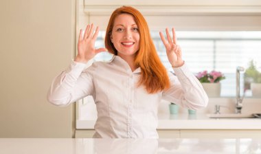 Kızıl saçlı kadına gösterilen ve parmakları ile işaret mutfak kendinden emin ve mutlu gülümseyerek süre sekiz numara.