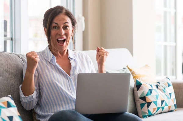 Mulher Meia Idade Usando Laptop Sofá Gritando Orgulhoso Celebrando Vitória — Fotografia de Stock