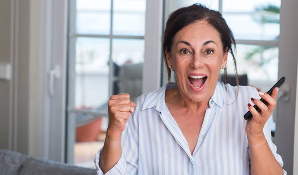 中年妇女使用智能手机尖叫自豪和庆祝胜利和成功非常兴奋 欢呼的情绪 — 图库照片