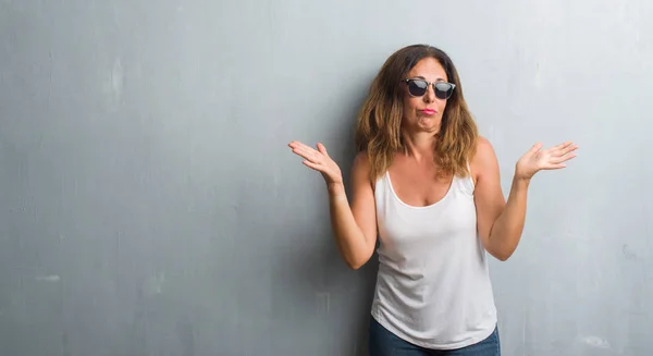 Hispanische Frau Mittleren Alters Über Grauer Wand Mit Sonnenbrille Ahnungsloser — Stockfoto